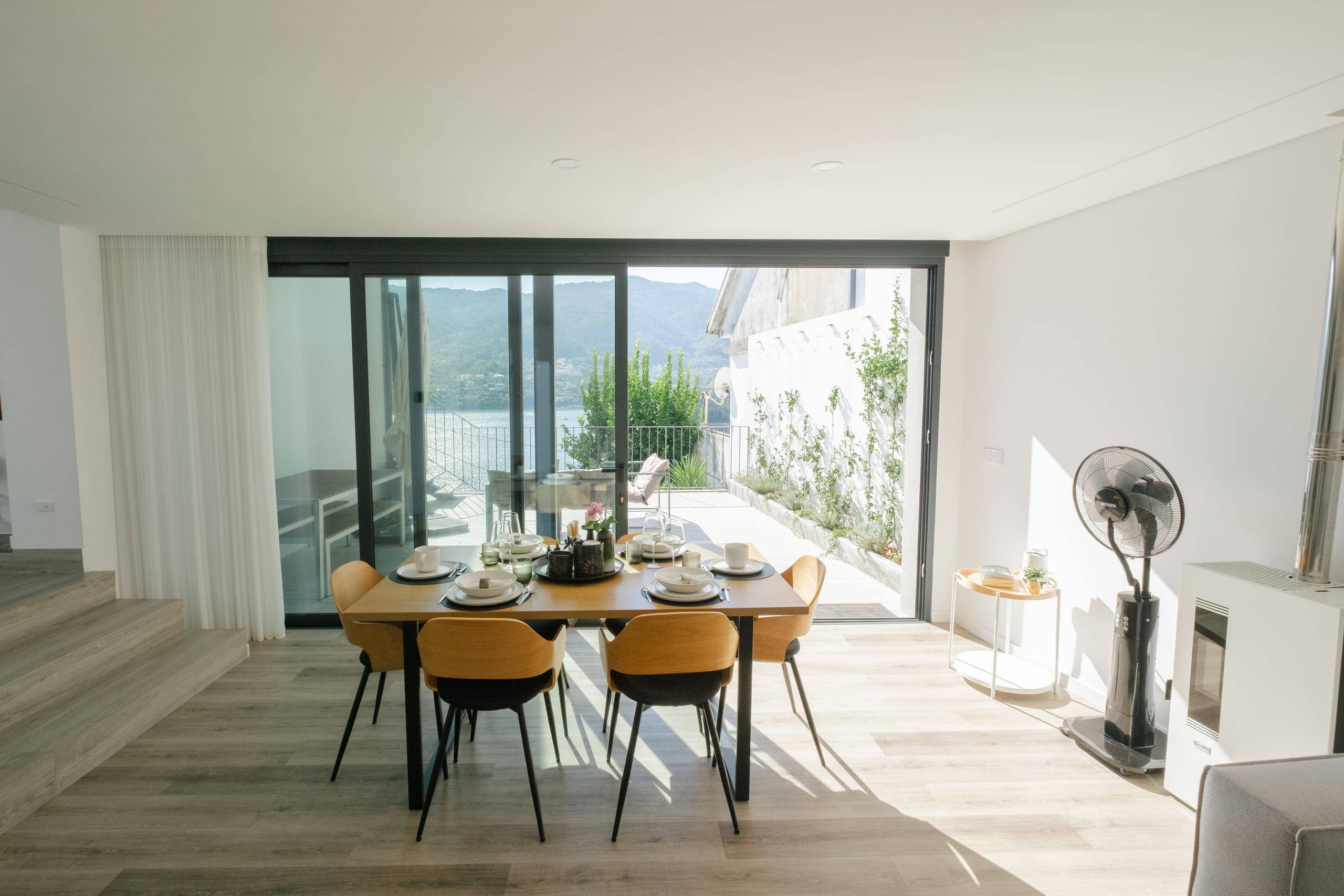 Mesa de jantar para seis pessoas junto às portas de vidro