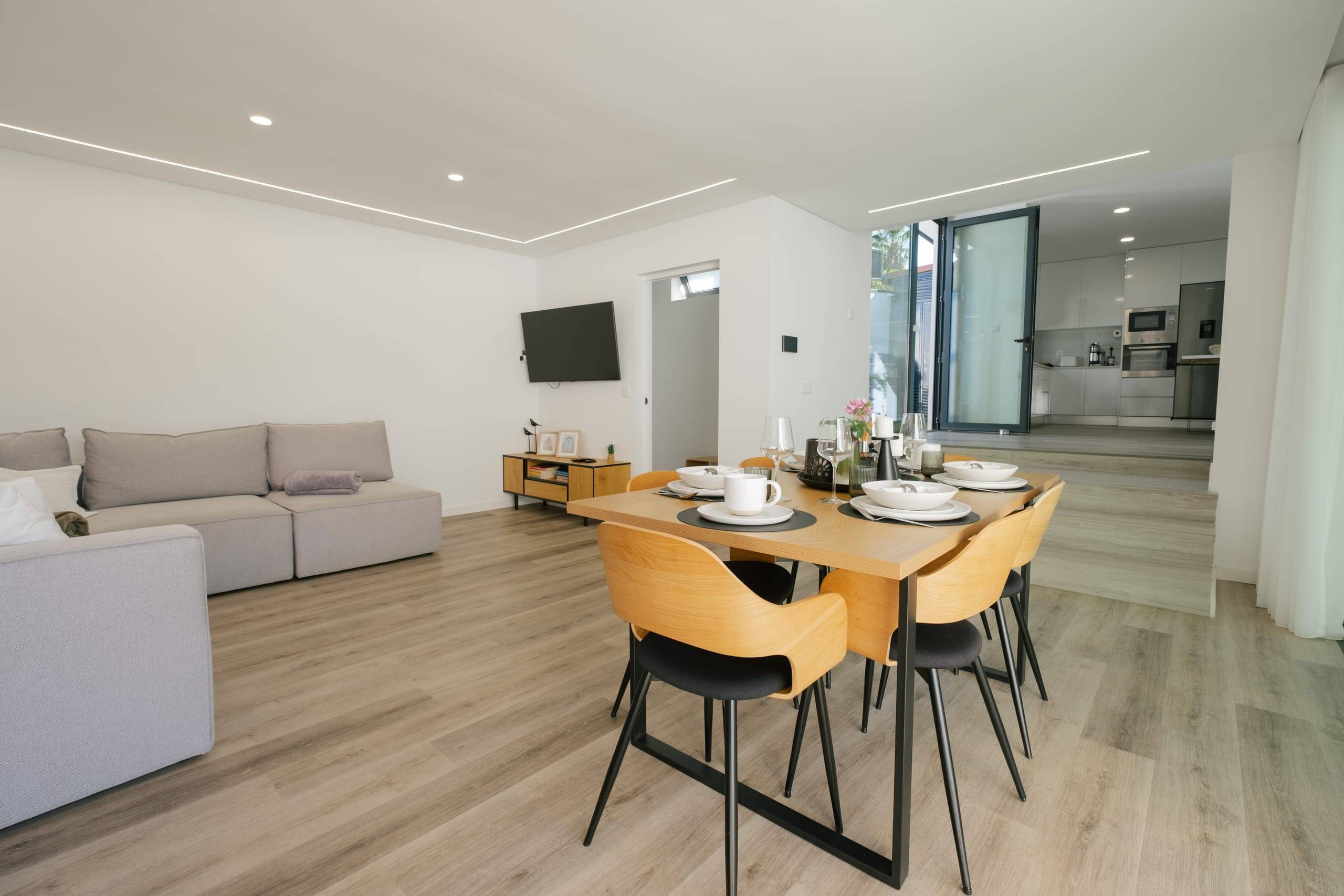 Sala de estar e jantar em open space com sofá e mesa para seis
