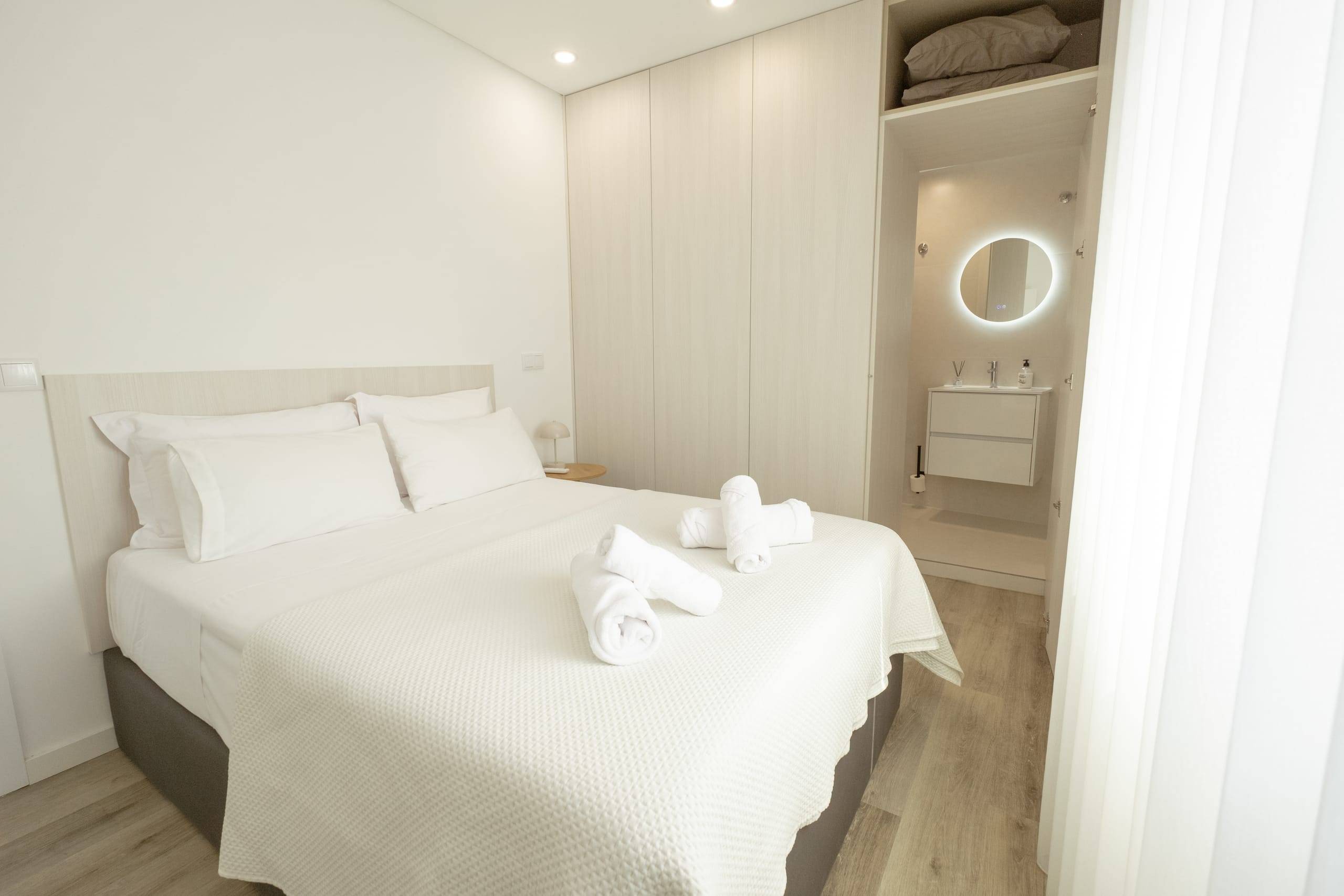 Suite com cama de casal, roupeiro e casa de banho privativa