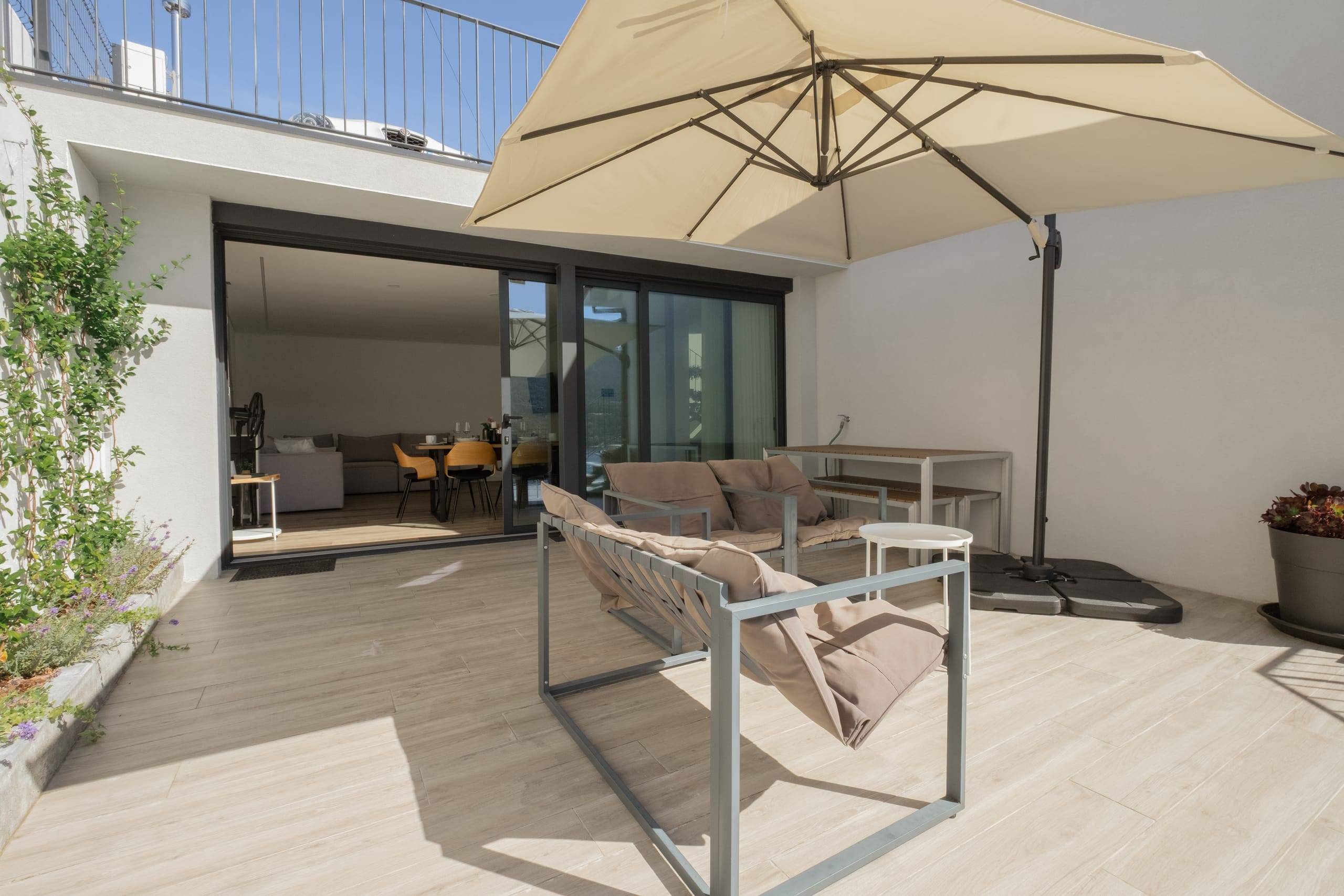 Terraço coberto por guarda-sol com acesso direto à sala